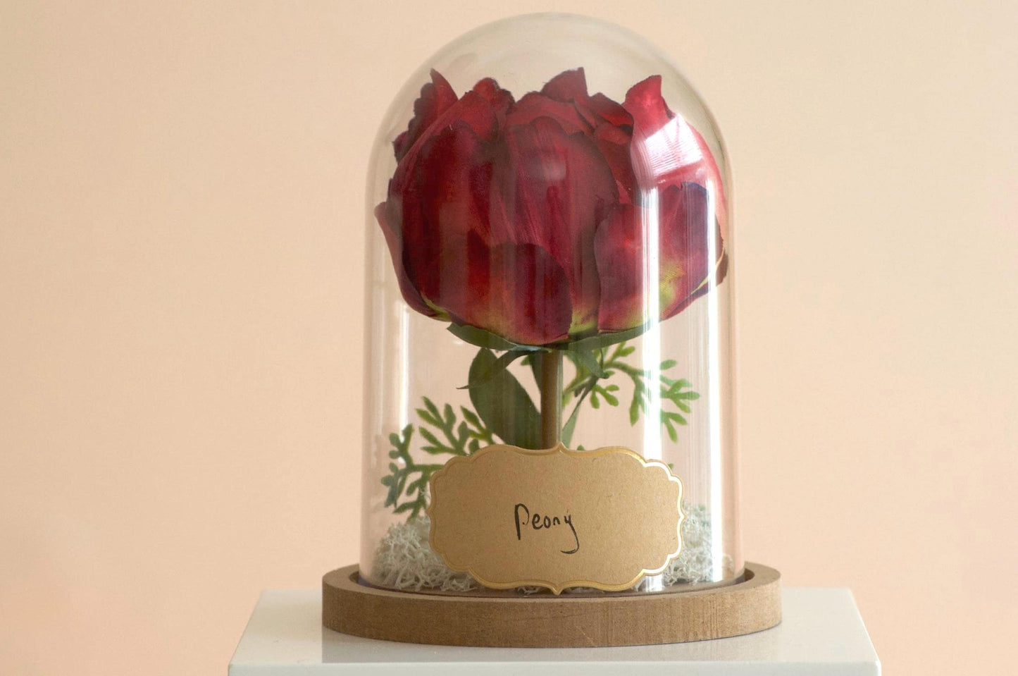 Peony silk flower arrangement inside of a flower cloche